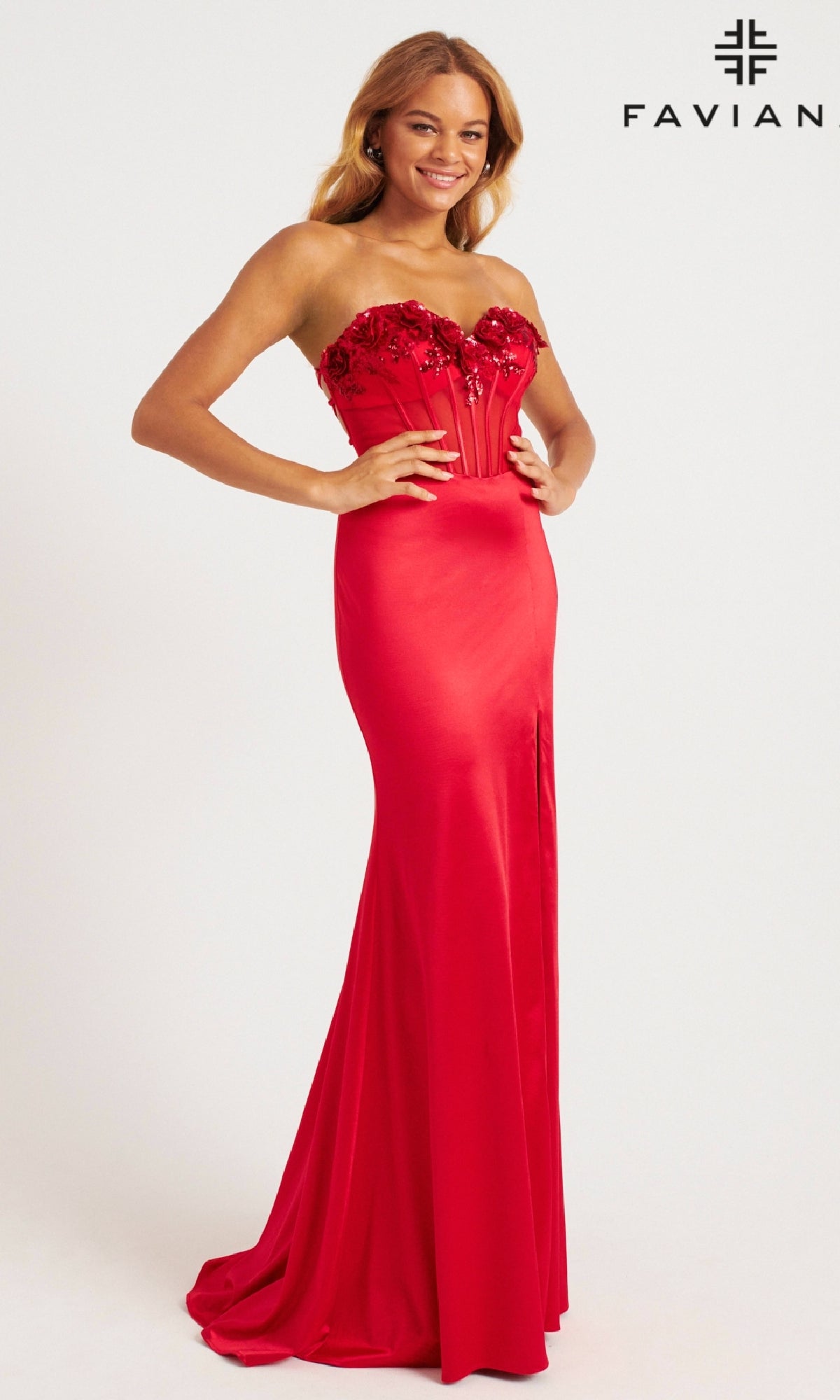 A woman smiles against a plain white background wearing the Faviana 11248 long prom dress, a strapless, floor-length red gown with floral-embellished corset bodice. The Faviana logo appears in the top right corner.